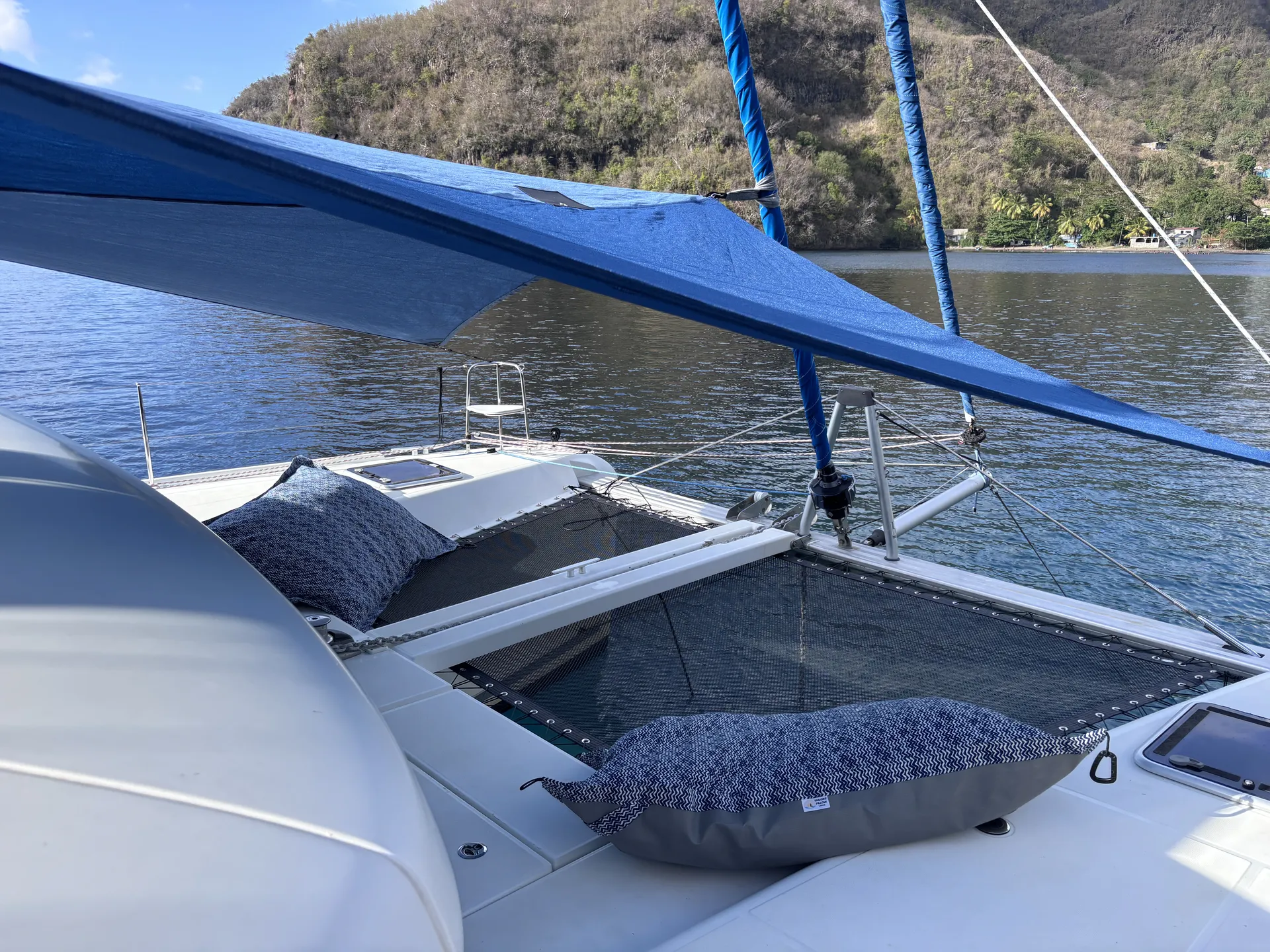 Under a custom blue Sunrise SHADE on a Lagoon 42, with Sailor's Pillows on the trampoline